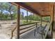 Inviting covered porch with rustic wood railings and ample space for relaxing and enjoying the serene outdoor view at 1651 Weldon Ln., Conway, SC 29526