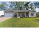 Charming single-story home featuring a well-manicured lawn, covered porch, and attached garage at 180 Oak Crest Circle, Longs, SC 29568