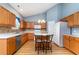 Bright kitchen with wood cabinets, stainless steel dishwasher, and a center island with barstool seating at 180 Oak Crest Circle, Longs, SC 29568
