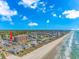 Expansive aerial view of an oceanfront community with a pristine beach under a bright blue sky and scattered clouds at 1801 N Ocean Blvd. # A4, North Myrtle Beach, SC 29582