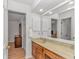 Bathroom featuring wood cabinets, a large mirror, and bright lighting at 1801 N Ocean Blvd. # A4, North Myrtle Beach, SC 29582