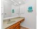Bathroom sink with a wooden vanity, a large mirror, and beach decor at 1801 N Ocean Blvd. # A4, North Myrtle Beach, SC 29582