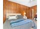 Bedroom featuring wood paneling, vinyl floors, ceiling fan, and Queen-sized bed with blue accents at 191 Maison Dr. # B-319, Myrtle Beach, SC 29572
