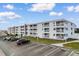Inviting low-rise condos with private balconies, manicured lawns, and ample parking under a bright blue, cloudy sky at 191 Maison Dr. # B-319, Myrtle Beach, SC 29572