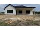 New construction with a modern farmhouse design, black windows, and a covered patio with support columns at 204 Shady Pines Ct., Conway, SC 29527
