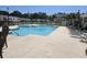 Large community swimming pool with clear blue water, lounge chairs and surrounding neighborhood under a bright sky at 213 Cupola Dr., Longs, SC 29568