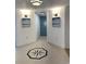 Hallway featuring artwork, sconces, a compass floor tile, and a blue door at 2151 Bridgeview Ct. # 3-305, North Myrtle Beach, SC 29582