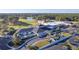 Aerial view of the clubhouse with outdoor seating, flags, landscaping, and a paved drive at 220 Clubhouse Dr. # 20B, Sunset Beach, NC 28468