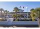 Exterior of the community building featuring manicured landscaping, flags, and a grand entrance at 220 Clubhouse Dr. # 20B, Sunset Beach, NC 28468