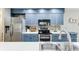 Updated kitchen with blue cabinets, stainless steel appliances, and stylish backsplash at 220 Clubhouse Dr. # 20B, Sunset Beach, NC 28468