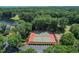 Aerial view of community tennis courts surrounded by lush greenery and ample parking at 220 Clubhouse Dr. # 20B, Sunset Beach, NC 28468
