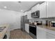 Modern kitchen with stainless steel appliances, white cabinets, granite countertops, and hardwood floors at 234 Belmonte Dr., Myrtle Beach, SC 29588