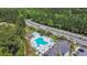 Aerial view showcases community pool and surrounding landscaping with lush green trees at 254 Tall Palms Way, Little River, SC 29566