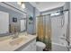 Bathroom featuring a single sink vanity, large mirror, and shower-tub combination with a shell-themed curtain at 254 Tall Palms Way, Little River, SC 29566
