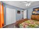 Comfortable bedroom featuring a bed with floral comforter, closet, and television on dresser at 254 Tall Palms Way, Little River, SC 29566