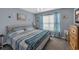 Bright bedroom with a comfortable bed, window with curtains, and beach-themed decor at 254 Tall Palms Way, Little River, SC 29566