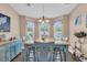 Sunny dining room features a modern table, stylish blue chairs, and an elegant chandelier at 254 Tall Palms Way, Little River, SC 29566