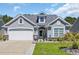 Charming single-story home featuring a stone-accented facade, well-manicured lawn, and a two-car garage at 254 Tall Palms Way, Little River, SC 29566