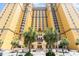 Grand hotel exterior featuring a welcoming entrance, bright facade, and verdant palm trees at 2600 N Ocean Blvd. # 1401, Myrtle Beach, SC 29577