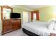Well-lit main bedroom featuring a wooden dresser, television, and doorway at 2600 N Ocean Blvd. # 1401, Myrtle Beach, SC 29577