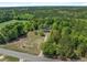 Aerial shot of home nestled amongst a lush landscape of dense trees and a well-kept lawn at 2865 N Nichols Hwy., Nichols, SC 29581