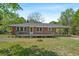 Charming red brick home featuring a spacious front porch and a convenient carport at 2865 N Nichols Hwy., Nichols, SC 29581