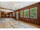 Living room showcasing wood paneling and multiple windows, leading to the kitchen and front door at 2865 N Nichols Hwy., Nichols, SC 29581