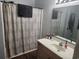 Well-lit bathroom features a vanity with storage and a shower with patterned shower curtain at 328 Harbour Reef Dr., Myrtle Beach, SC 29588