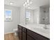 Bright bathroom featuring double sinks, wood-look flooring, and large vanity mirror at 343 Barn Owl Way, Conway, SC 29527