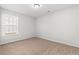 Empty bedroom with neutral walls, tan carpet, and a window with a view of the outdoors at 343 Barn Owl Way, Conway, SC 29527