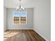 Bright dining room with modern chandelier and wood-look flooring overlooks the outside at 343 Barn Owl Way, Conway, SC 29527