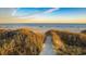 Sandy path leading to a serene beach with calm waters at sunset at 35 Red Skiff Ln. # 35, Pawleys Island, SC 29585