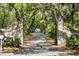 Grand entrance framed by brick columns and lush trees, leading to a private and scenic driveway at 35 Red Skiff Ln. # 35, Pawleys Island, SC 29585