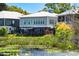 Rear exterior view of gray two-story home with back porch overlooking the water at 35 Red Skiff Ln. # 35, Pawleys Island, SC 29585
