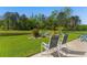 Serene backyard featuring a lush lawn, pond, garden, and patio with chairs, perfect for outdoor relaxation at 363 Cypress Springs Way, Little River, SC 29566