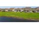 Aerial view of the backyard showcasing a pond, well-manicured lawn, and patio areas with seating at 363 Cypress Springs Way, Little River, SC 29566