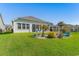 Spacious backyard with lush green lawn, patio, and a beautiful landscaped garden at 363 Cypress Springs Way, Little River, SC 29566
