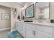 Bright bathroom with double sinks, white cabinetry, framed mirrors, and decorative accents at 363 Cypress Springs Way, Little River, SC 29566