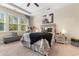 Comfortable bedroom with tray ceilings, large windows, a queen-sized bed, and a bench at 363 Cypress Springs Way, Little River, SC 29566