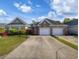 View of the home's exterior showing the two-car garage, driveway, and manicured lawn at 400 Woodpecker Ln. # 17B, Murrells Inlet, SC 29576
