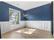 Bedroom featuring hardwood floors, blue accent wall and white trim around the large sunny window at 405 Emerson Dr., Myrtle Beach, SC 29579