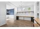 Home office with custom built-in desk, shelving and an adjacent room with wood floors and blue walls at 405 Emerson Dr., Myrtle Beach, SC 29579