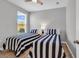 Inviting bedroom showcasing two twin beds with blue and white striped bedding and a ceiling fan at 4061 Taranto Loop # A, Myrtle Beach, SC 29579