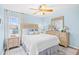 Cozy bedroom with light blue walls, a decorative ceiling fan, and ample natural light at 410 N Waccamaw Dr. # 306, Murrells Inlet, SC 29576