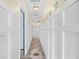 Bright, neutral hallway with paneled walls and decorative rug runner at 410 N Waccamaw Dr. # 306, Murrells Inlet, SC 29576