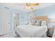 Comfortable bedroom featuring an ensuite bathroom, a ceiling fan, and a large sunny window at 410 N Waccamaw Dr. # 306, Murrells Inlet, SC 29576
