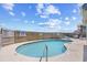 Inviting outdoor pool area featuring a safety fence, signage, and lounge chairs for relaxation at 410 N Waccamaw Dr. # 306, Murrells Inlet, SC 29576