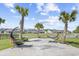 Inviting backyard oasis featuring comfortable hammocks, lush lawn, serene pond view, and mature palms at 422 Harbour View Dr., Myrtle Beach, SC 29579