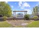 Elegant community entrance sign with white columns, lush landscaping, and a black iron fence at 422 Harbour View Dr., Myrtle Beach, SC 29579