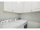 Functional laundry room with white cabinets, a washing machine, and a dryer at 422 Harbour View Dr., Myrtle Beach, SC 29579
